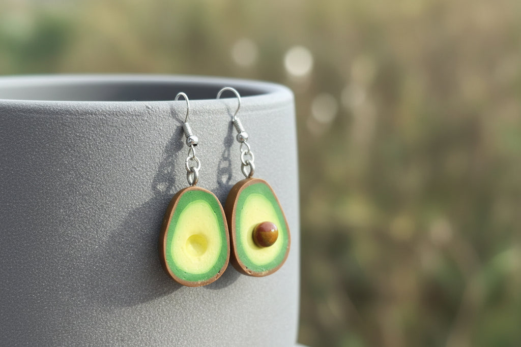Grüne Avocado Ohrringe aus Polymer Clay handgefertigt vor grauem Hintergrund