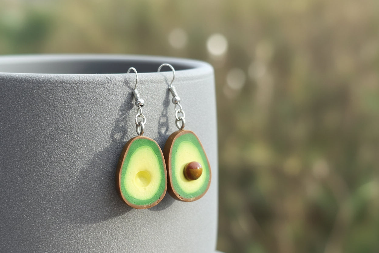Grüne Avocado Ohrringe aus Polymer Clay handgefertigt vor grauem Hintergrund